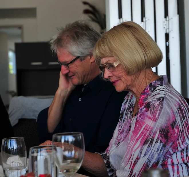 an old couple sitting together at a dinner table