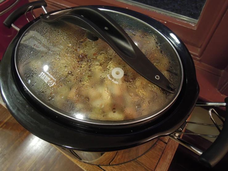 an iron pot has food in it on top of the table