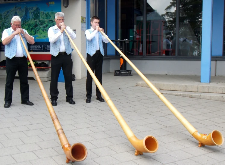 a line of four trombone instruments on a sidewalk