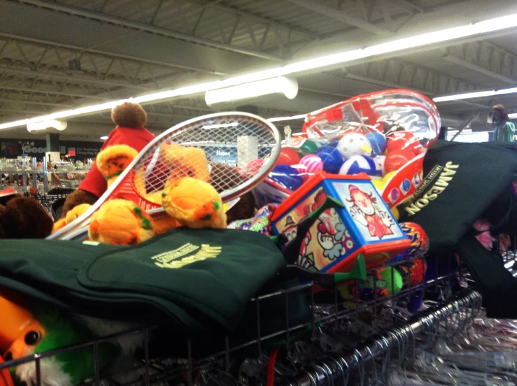 a racket and stuffed animals are piled up in a display