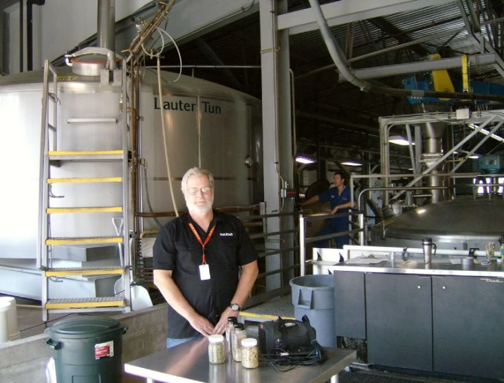 a man standing in an industrial area by a water heater