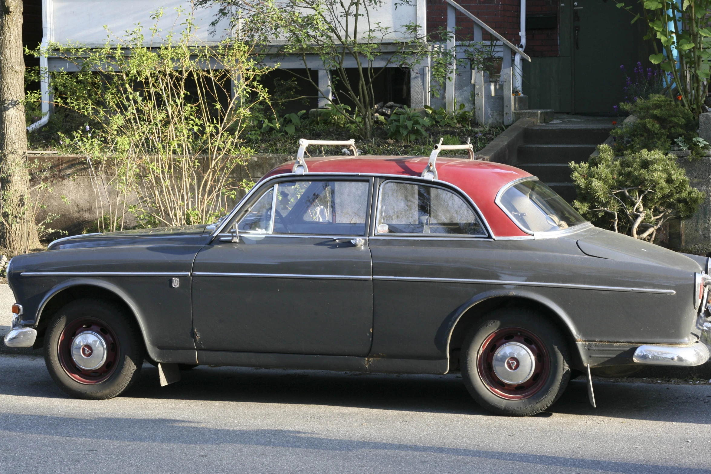 an old brown car with a surfboard on top