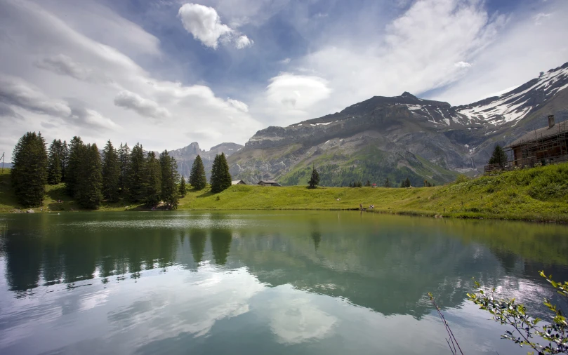 a beautiful view of mountains and water near green hills