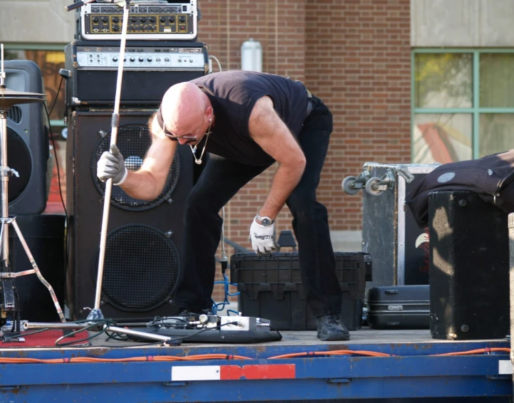 a man in black shirt doing a project on a big blue truck