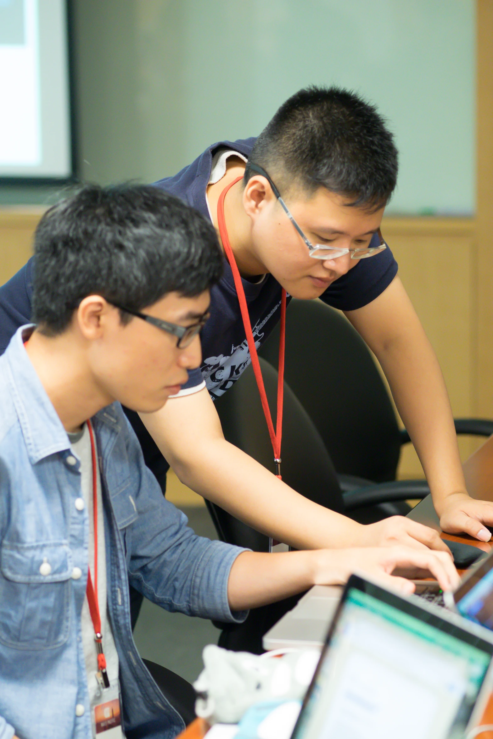 two guys at a table in front of computers