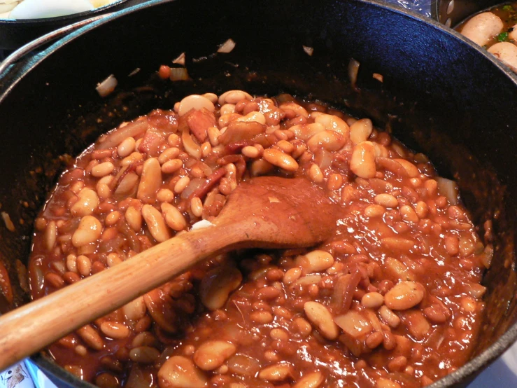 beans and bacon are being cooked in a pot