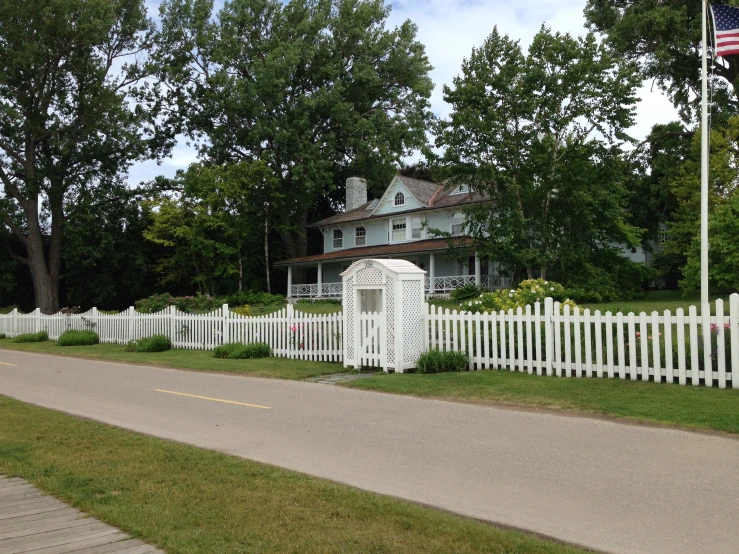 a small picket fence sits along the road