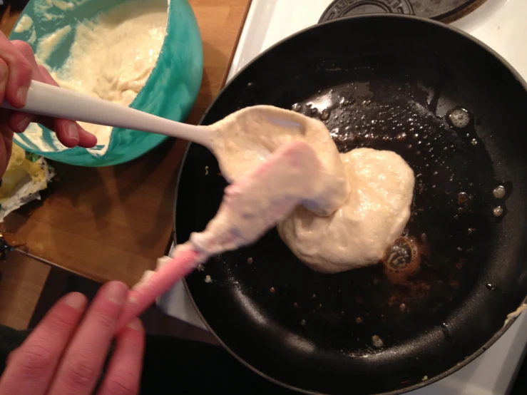 someone stirring eggs in a pan with a spatula