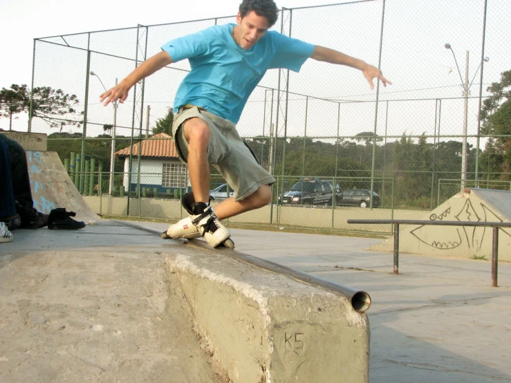 a boy riding a skateboard on the edge of a ramp