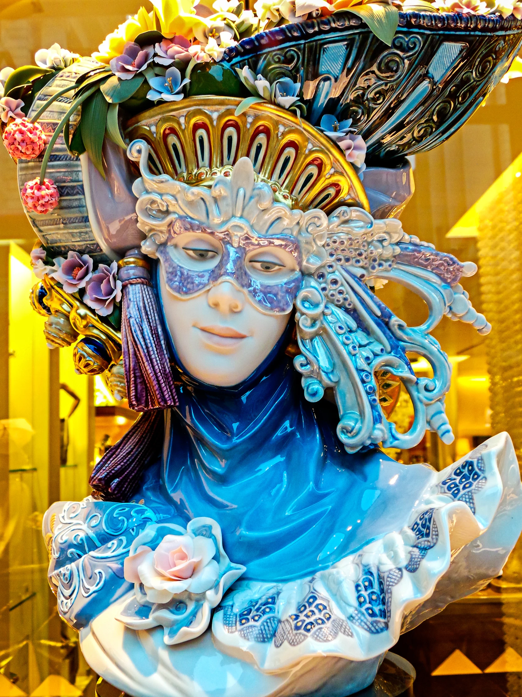 a sculpture of a woman with large hair and ornate blue headgear