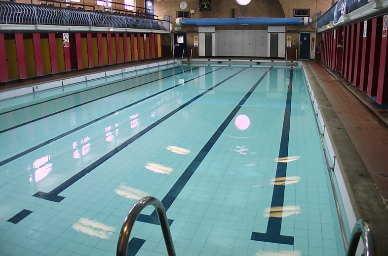 the empty swimming pool is in a large building