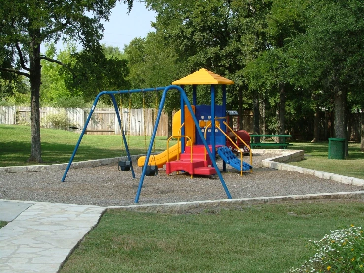 a blue and yellow swing set in the park