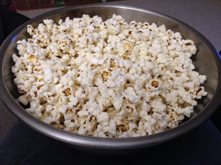 there is a metal bowl full of popcorn