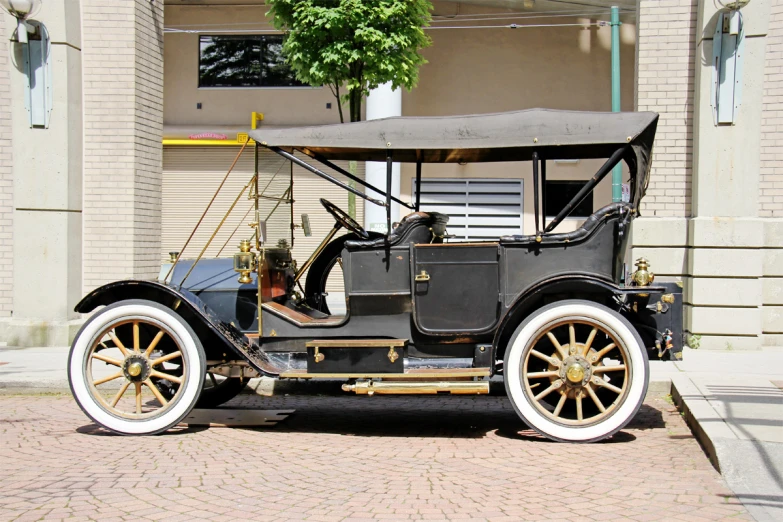an antique model t car is parked in front of a building