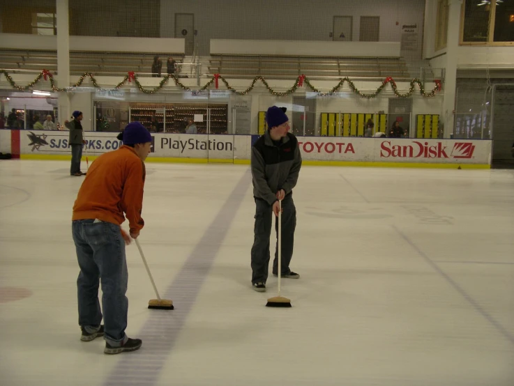 two young men standing on top of an ice rink