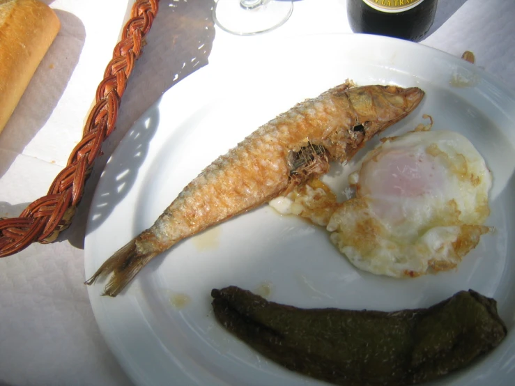 an open fish with eggs and other food on a plate