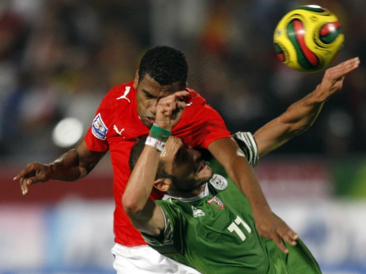 two soccer players battle for control of the ball