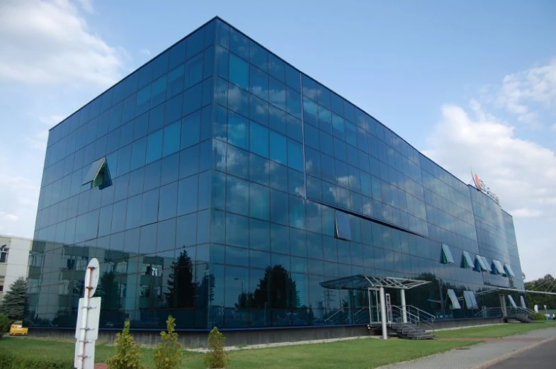 there is a very large glassy building with a sky background