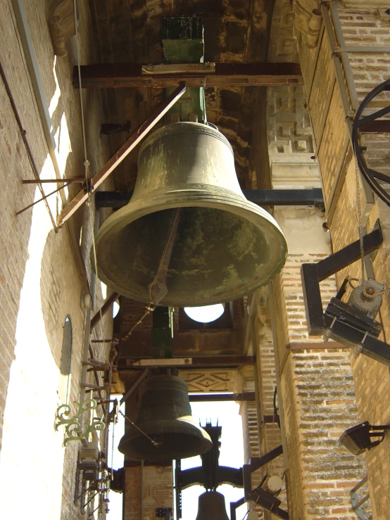 two bell bells attached to a building and other things hanging