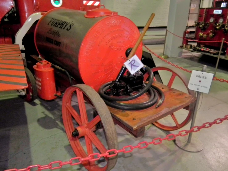 a red wheel barrow sitting on display in a warehouse