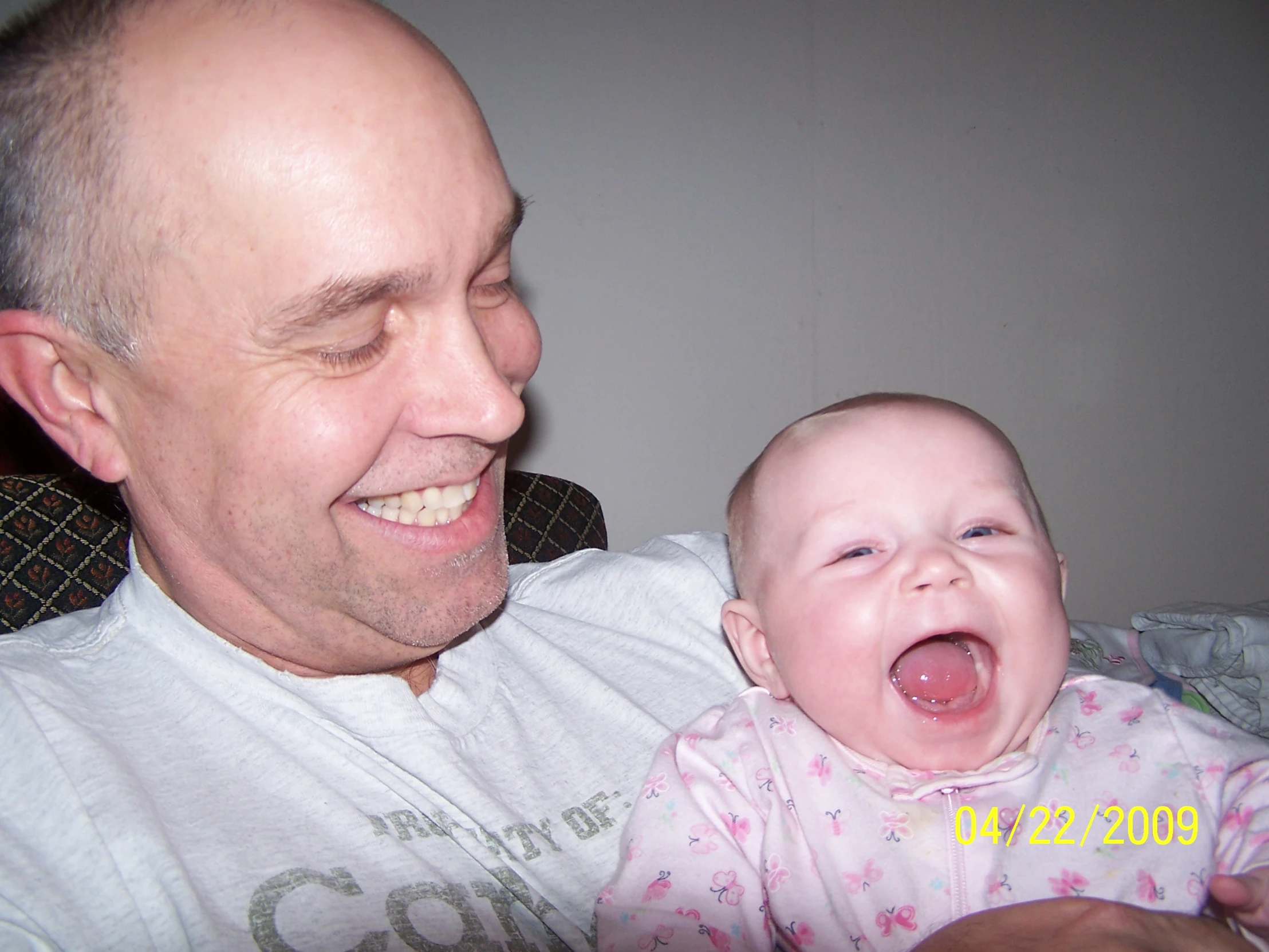 a man is smiling while he holds his baby