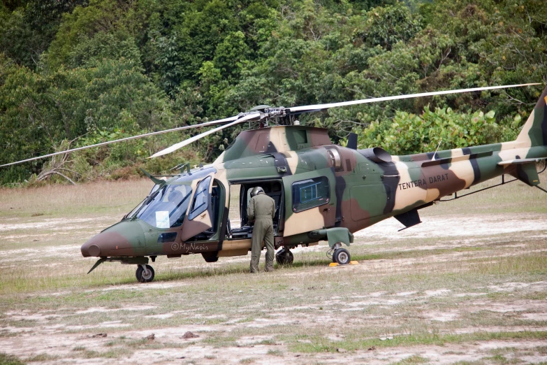 a man walking toward a helicopter parked on the grass