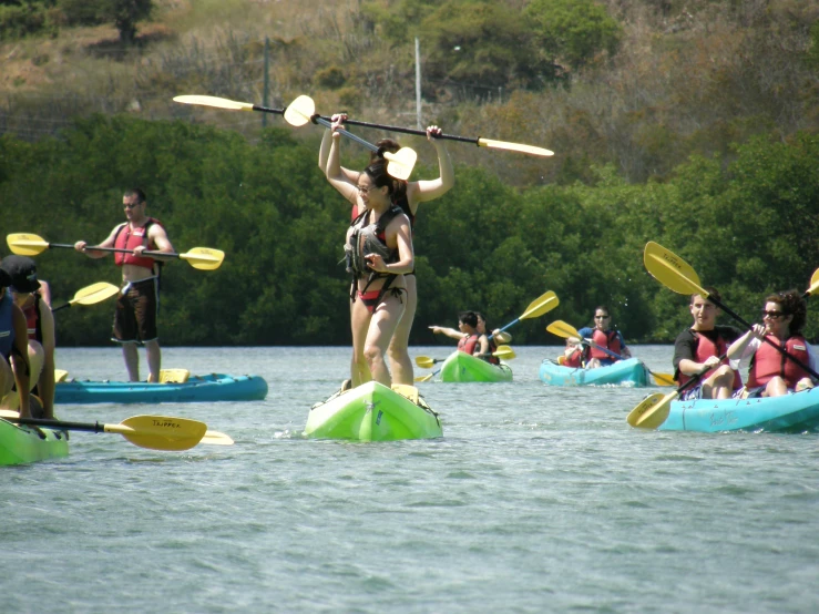 a group of people on kayaks paddle down the river