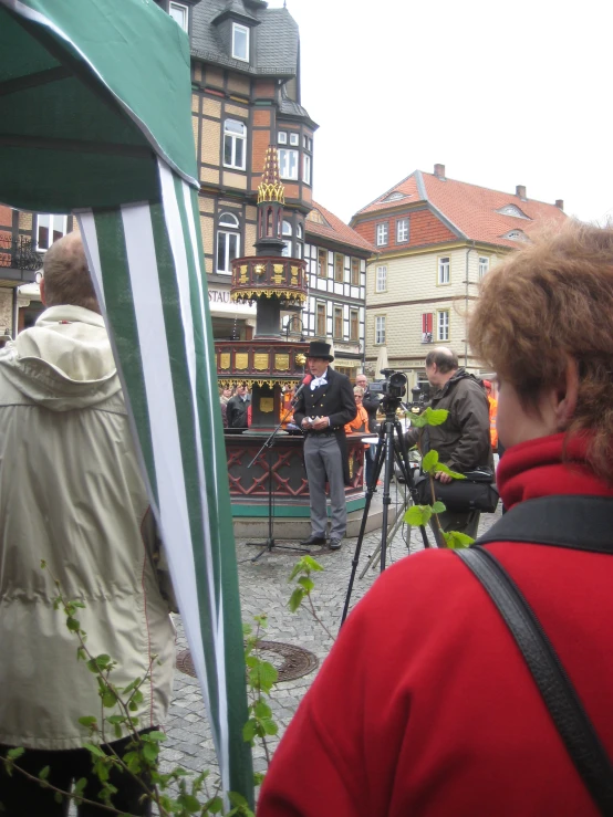 several pographers and other people near buildings and trees