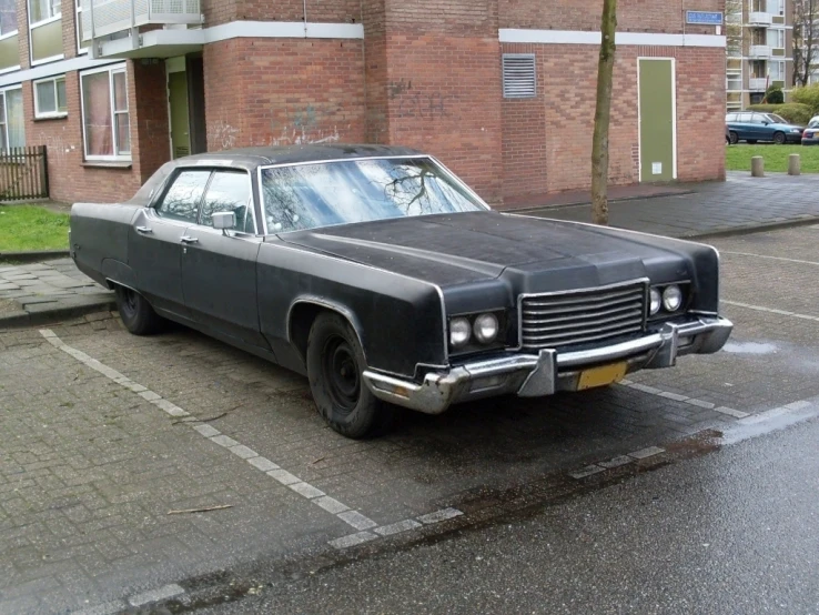 a black car is parked on the side of the road