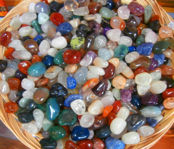 assortment of multi - colored rocks in basket for sale