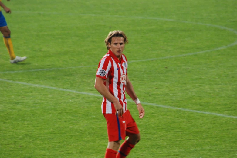 a man in striped uniform standing on a soccer field