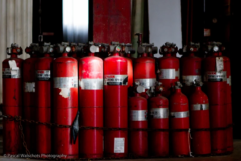 a pile of fire extinguishes in front of a door