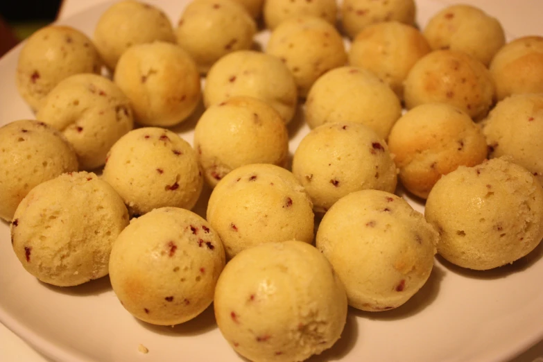 a bunch of small balls of pastries are arranged on a plate