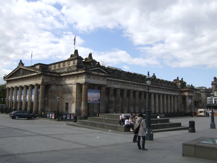 people standing outside an ornate building on the corner