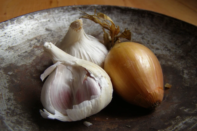 an onion and two garlic on a plate