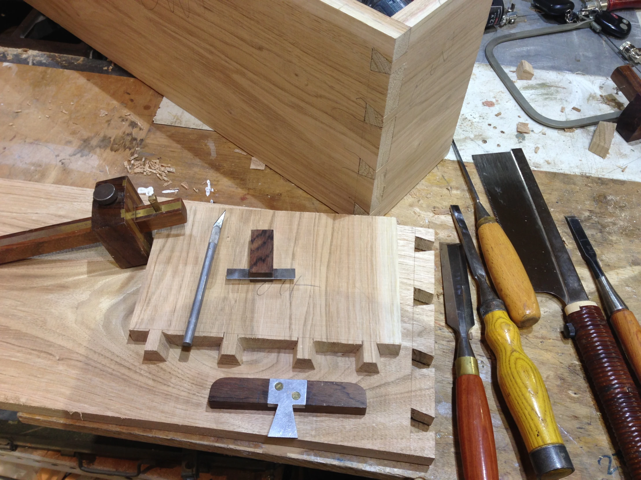 various tools are on a workbench with woodworking material