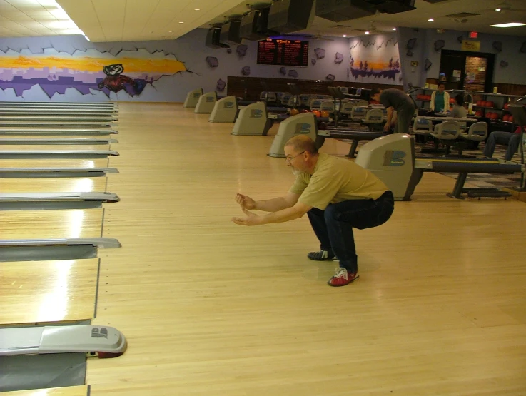 there is a man standing in a bowling alley