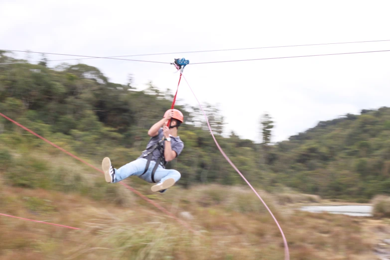 a man on the air trying to zip in a field