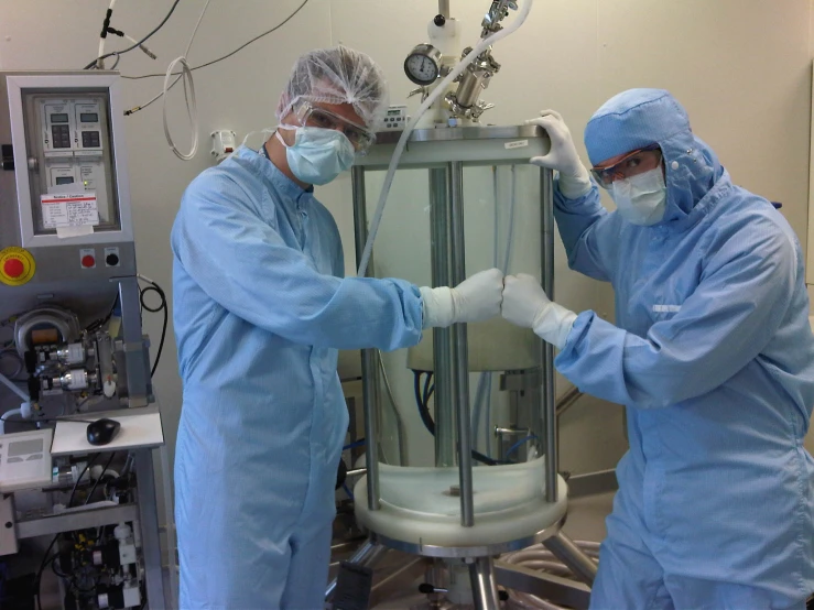 two doctors working on a device in a hospital room