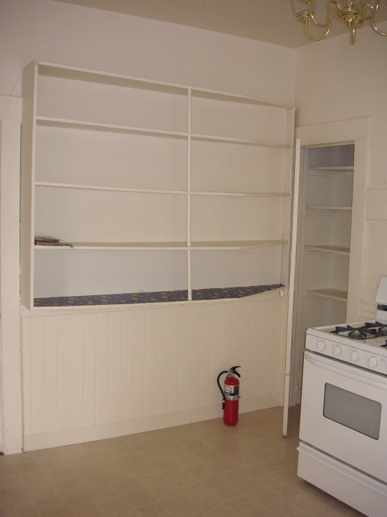 a stove in a white room next to a white wall