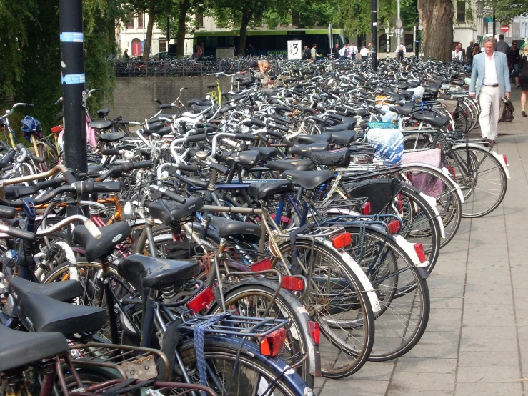 a bunch of bikes are parked on a side walk