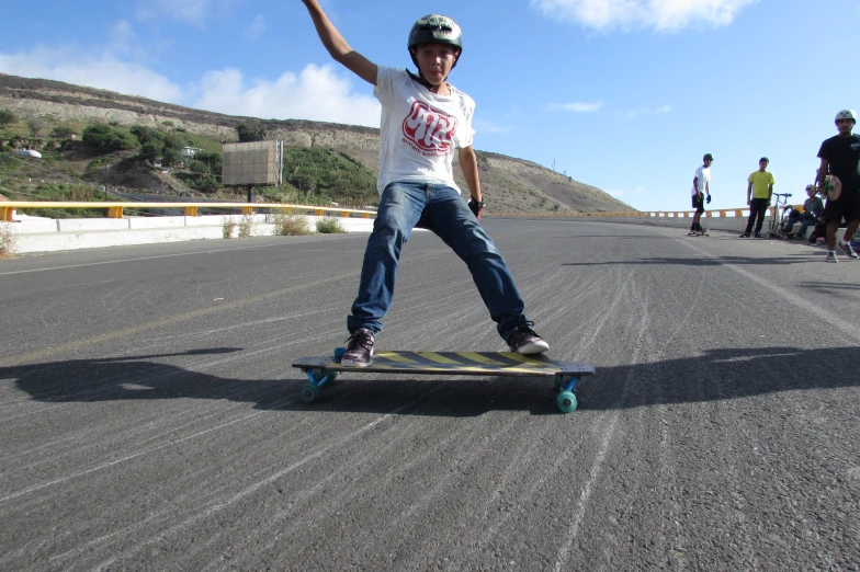 a skateboarder riding down an empty road on his board