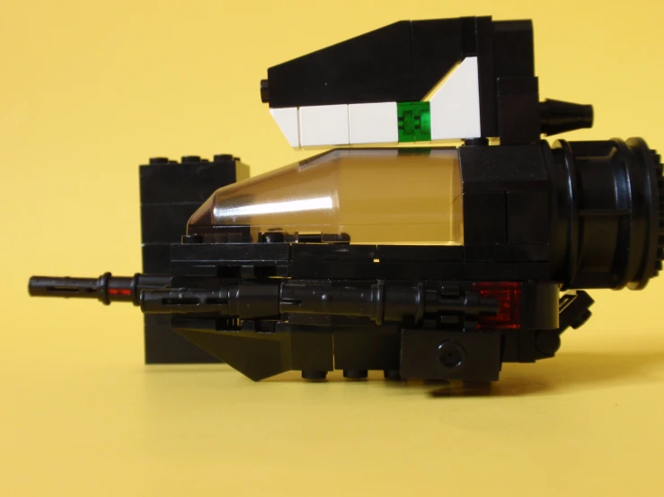 a lego gun is sitting next to some other toys