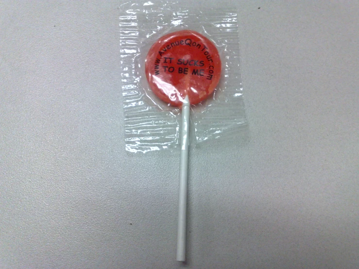 a candy lollipop is wrapped in plastic on the floor