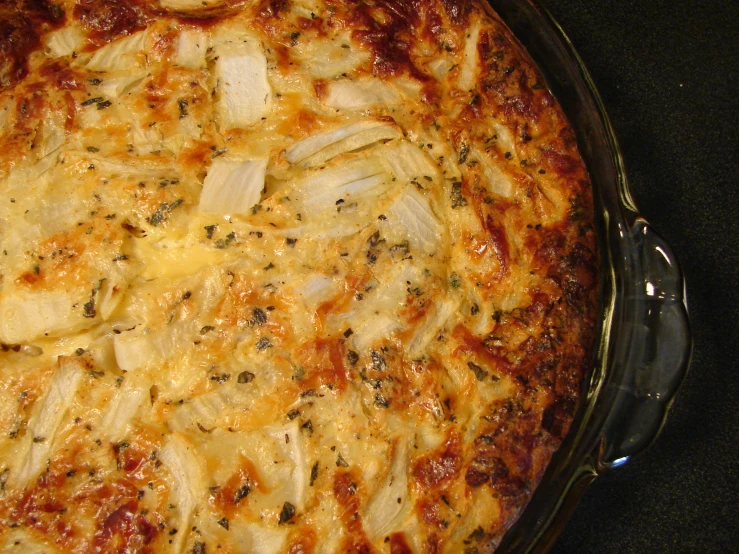 a cooked pizza in a pan sitting on the stove