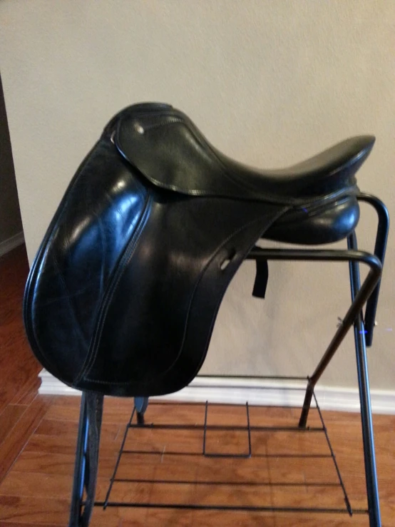 a saddle on top of a steel stand against a wall