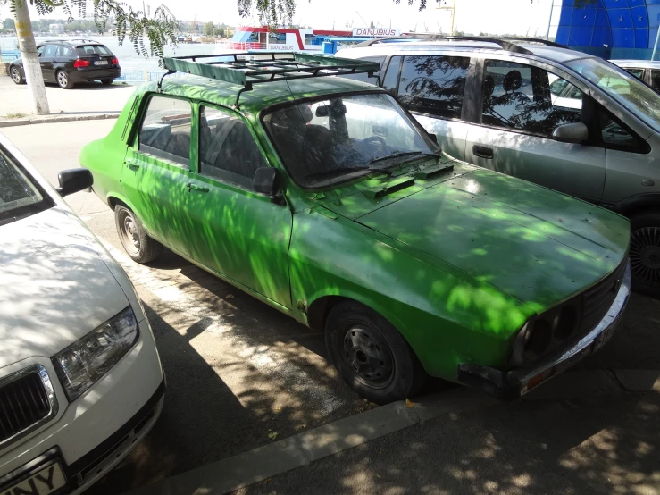 a green car parked next to some other cars