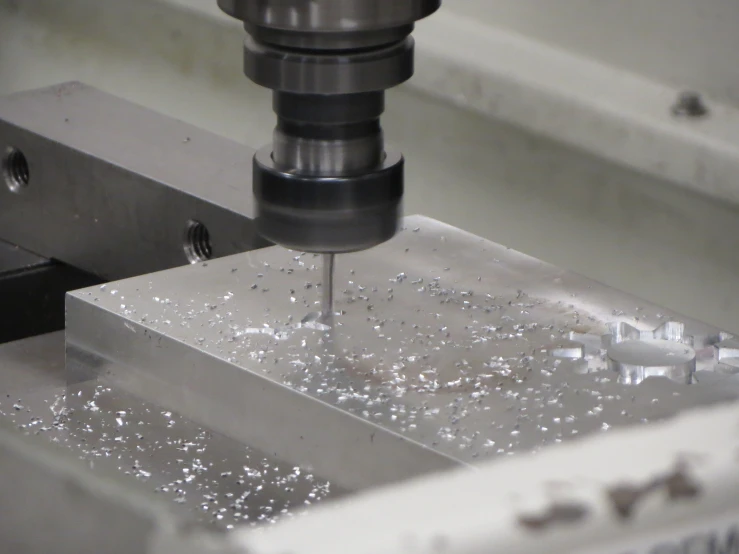 a metal milling machine cuts into an individual square