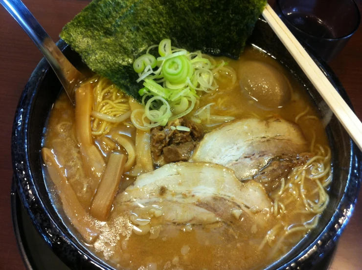 a bowl full of noodles, meat, and broccoli