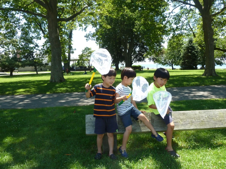 three s pose for the camera on a bench